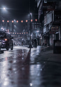 Illuminated city street during rainy season at night