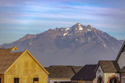 Low angle view of houses and mountains against sky