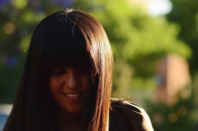 Close-up portrait of a smiling young woman outdoors