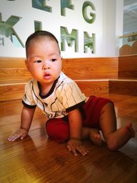 Cute boy playing on hardwood floor at home