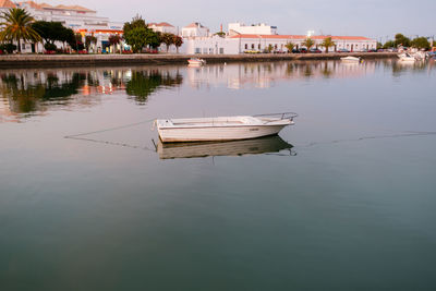 Boat moored on lake against sky