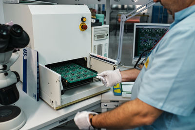 Trabajador introduciendo placa en una maquina