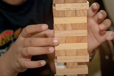 Midsection of boy playing with wooden blocks