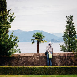 Man standing by tree against sky