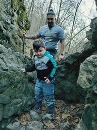 Full length of children on rock against trees