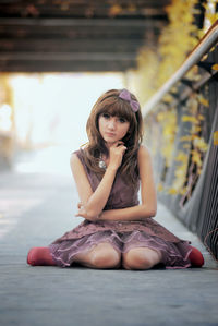 Full length of woman kneeling on footbridge