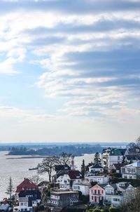 High angle view of houses by sea against sky