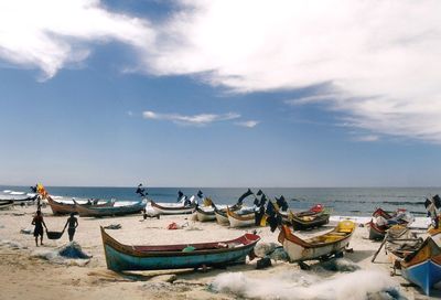 Boats moored on beach against sky