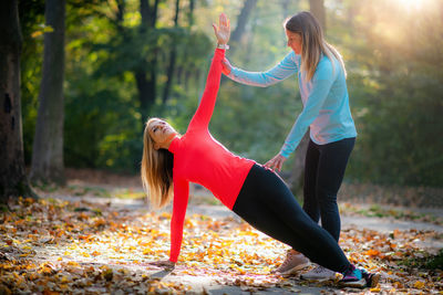 Personal fitness trainer using smart watch during training in the park. woman doing plank.