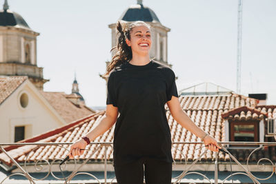 Sporty woman in stylish sportswear doing the jump rope exercise during the workout on the  rooftop 