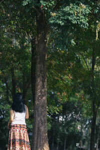 Rear view of woman standing by tree