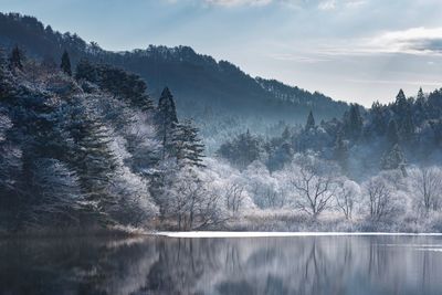 Scenic view of lake against sky during winter