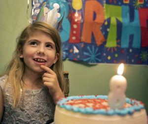 Portrait of young woman blowing birthday candles