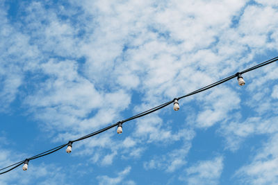 Low angle view of power cables against sky