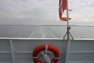 Red flag on sea against sky