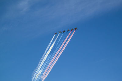 Low angle view of airplane flying against blue sky