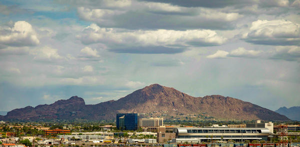 Aerial view of townscape and mountains against sky