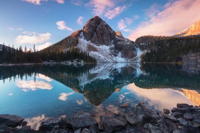 Scenic view of lake and mountains against sky during sunset