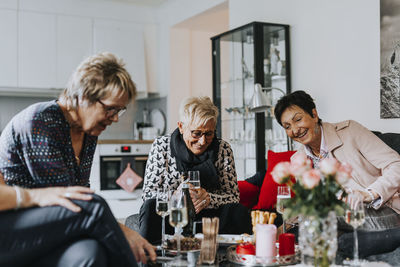 Happy senior friends sitting in living room