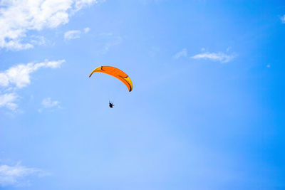 Low angle view of person paragliding against sky