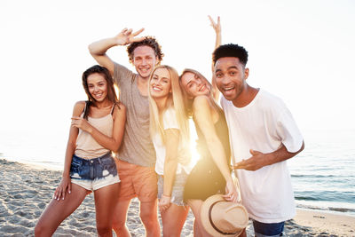 Portrait of smiling young friends at beach