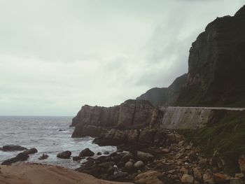 Rocks on beach against sky