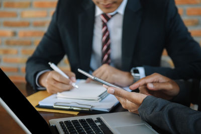 Midsection of businessman working at office