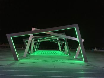 Low angle view of illuminated bridge against sky at night