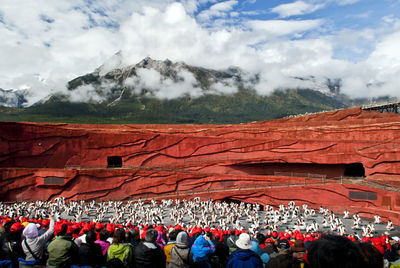 Group of people on mountain against sky