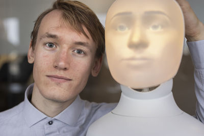 Portrait of young man with robot voice assistant