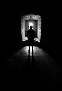 Rear view of man walking in illuminated building