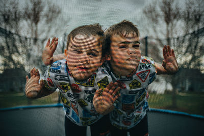 Twin boys being silly on trampoline