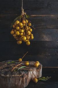 Longans hanging over wood against wall