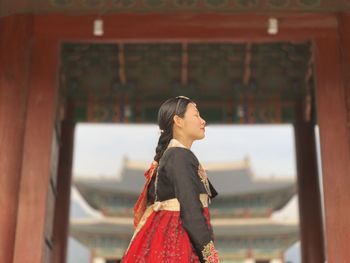 Side view of young woman looking away outdoors