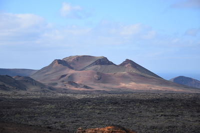 View of volcanic land against sky