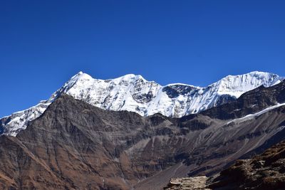 Scenic view of snowcapped mountains against clear blue sky