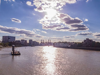 Scenic view of river by buildings against sky