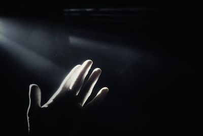 Sunlight falling on person hand in darkroom