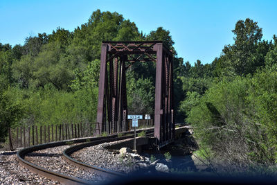 Bridge over trees in forest against sky