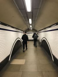 Rear view of people walking in subway station