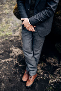 Low section of man standing on field