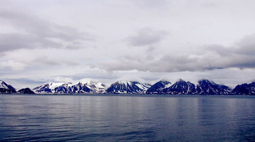 Scenic view of sea and mountains against sky