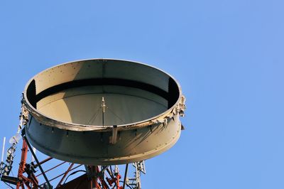 Low angle view of telecommunications pole against clear blue sky