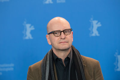 Portrait of man standing against blue sky