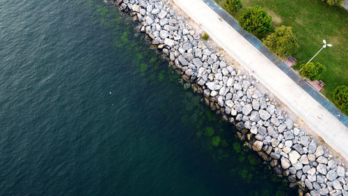 High angle view of stone wall by sea