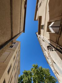 Low angle view of buildings against clear blue sky