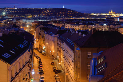 High angle view of illuminated street amidst buildings at night