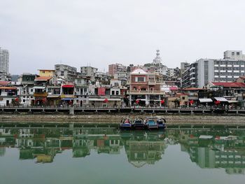 Reflection of buildings in lake against sky