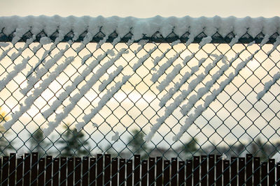 Fence by railing against sky