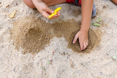 Low section of boy playing on sand